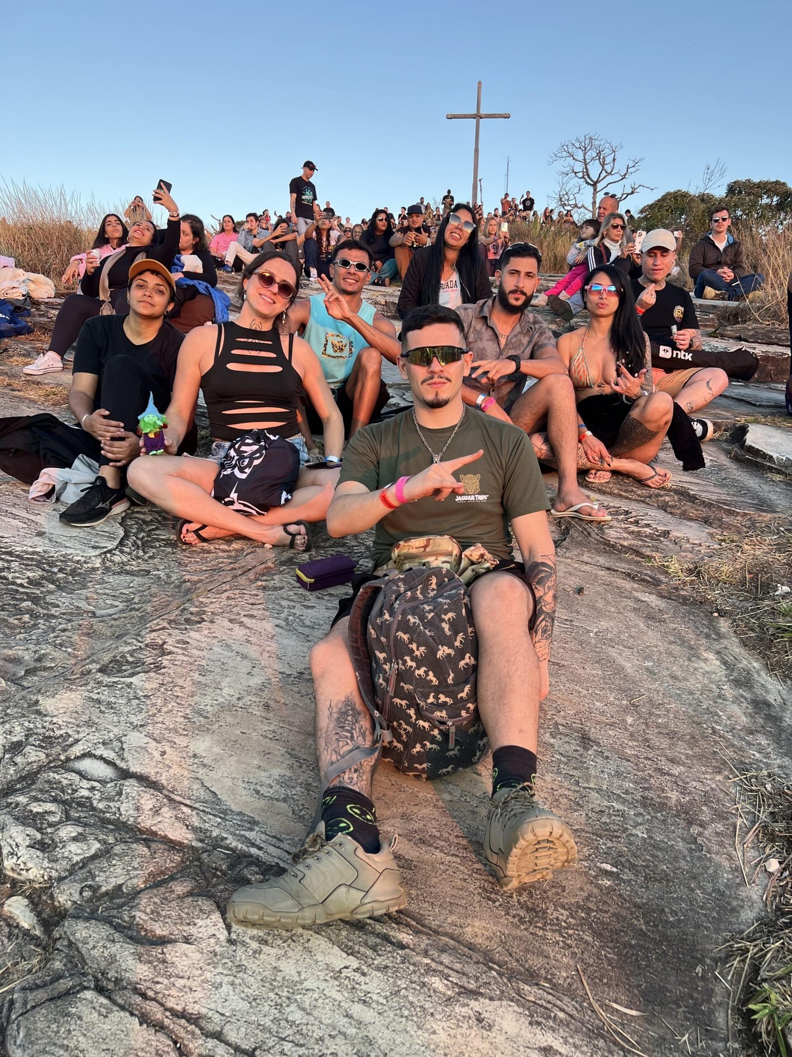 Tribo Jaguar Trips reunida no alto da pedra ao pôr do sol
