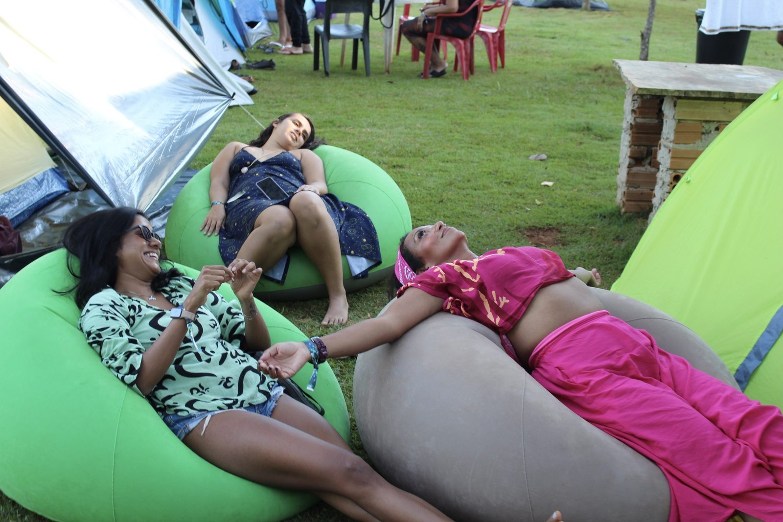 Viajantes relaxando em infláveis no camping